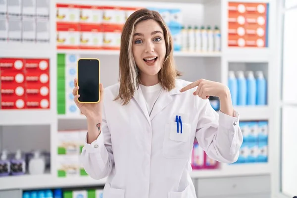 Blonde Caucasian Woman Working Pharmacy Drugstore Showing Smartphone Screen Pointing — Foto de Stock