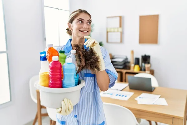 Mujer Rubia Joven Usando Uniforme Más Limpio Sosteniendo Productos Limpieza —  Fotos de Stock