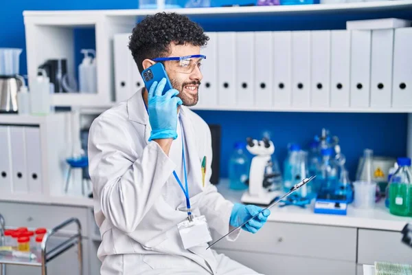 Young Arab Man Wearing Scientist Uniform Talking Smartphone Laboratory — Foto Stock