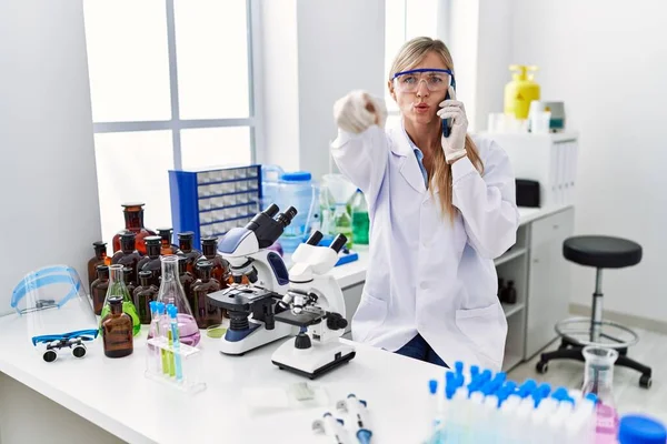 Beautiful Woman Working Scientist Laboratory Speaking Phone Pointing Finger Camera —  Fotos de Stock