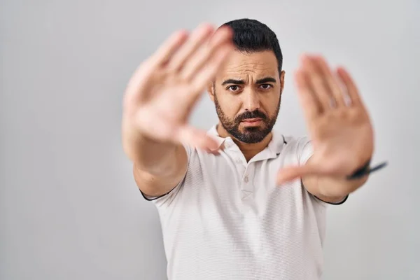 白い背景の上にカジュアルな服を着て髭を生やした若いヒスパニック系の男は 手の手のひらと指を使用してフレームを行う カメラの視点 — ストック写真