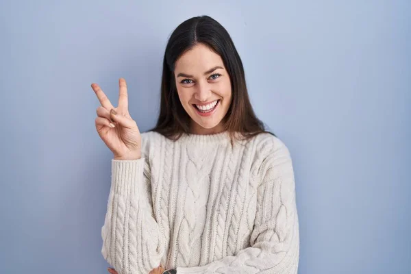 Jovem Morena Sobre Fundo Azul Sorrindo Com Rosto Feliz Piscando — Fotografia de Stock