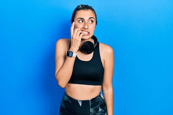 Beautiful Hispanic Woman Wearing Gym Clothes Using Headphones Looking Stressed — Zdjęcie stockowe