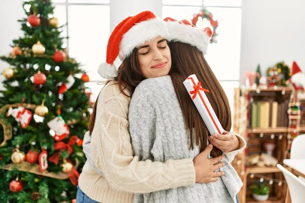 Dos Mujeres Sosteniendo Regalo Abrazándose Pie Junto Árbol Navidad Casa — Foto de Stock