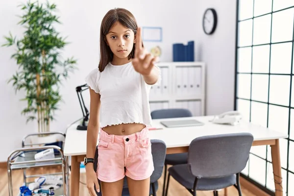 Young Hispanic Girl Standing Pediatrician Clinic Pointing Finger Angry Expression — Stock fotografie