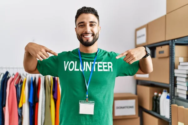 Jonge Arabier Man Wijzend Met Vingers Naar Vrijwilliger Uniform Liefdadigheidscentrum — Stockfoto