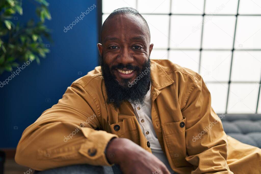 Young african american man smiling confident sitting on sofa at home