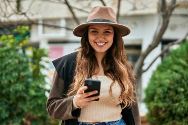 Şehirde akıllı telefon kullanan genç İspanyol turist kadın..