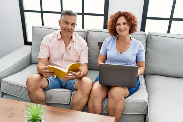 Medelålders Man Och Kvinna Par Använder Laptop Och Läsa Bok — Stockfoto