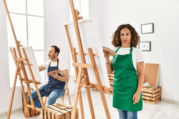 İspanyol orta yaşlı kadın ve sanat stüdyosunda olgun bir adam. Düşünce tarzı ve ayık ifadesi. Kendine güveni tam görünüyor. 