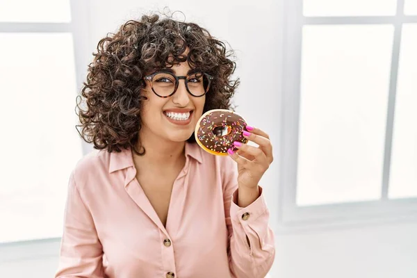 Jovem Empresária Oriente Médio Sorrindo Feliz Comer Donut Escritório — Fotografia de Stock