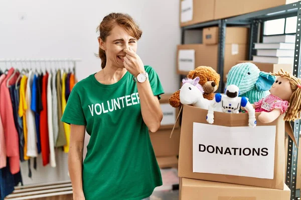 Mulher Branca Bonita Vestindo Shirt Voluntária Doações Stand Cheirando Algo — Fotografia de Stock