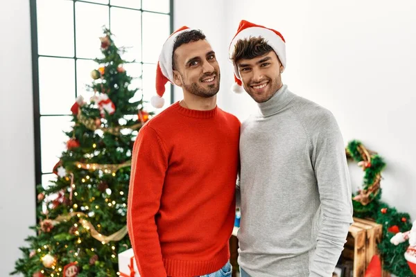 Genç Eşcinsel Çift Noel Ağacının Yanında Durmuş Şapkalarını Takmış Yan — Stok fotoğraf