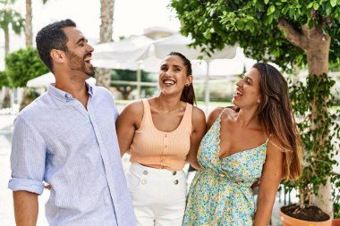 Üç İspanyol arkadaş şehirde mutlu bir şekilde gülüyor ve sarılıyorlar..