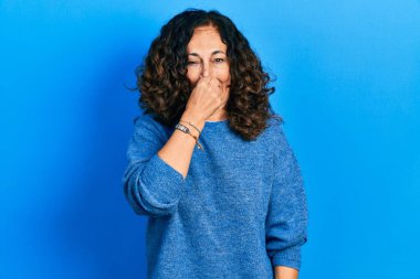 Orta yaşlı İspanyol kadın gündelik kıyafetler giyiyor. Kokuşmuş ve iğrenç bir koku alıyor. Dayanılmaz bir koku. Kötü kokuyor. 