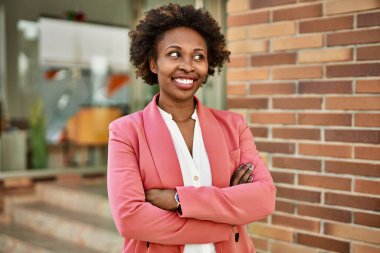 Güzel bir iş adamı Afro saçlı Amerikalı kadın şehirde mutlu ve kendinden emin bir şekilde gülümsüyor.