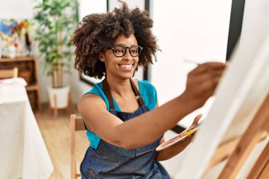 Genç Afrikalı Amerikalı kadın sanat stüdyosunda kendine güvenen bir çizim yapıyor.
