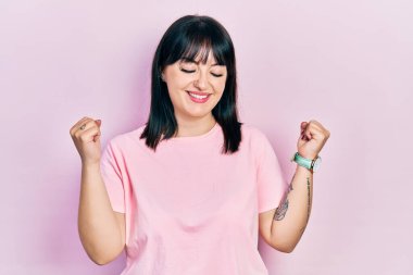 Genç İspanyol kadın gündelik kıyafetler giyiyor çok mutlu ve heyecanlı kazanan jestler yapıyor kolları havada, gülümsüyor ve başarı için bağırıyor. kutlama konsepti. 