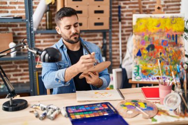 Genç İspanyol ressam resim çiziyor ve dans ediyor. Sanat stüdyosunda oturuyor.