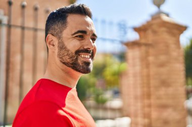 Sokakta kendinden emin gülümseyen İspanyol genç adam.