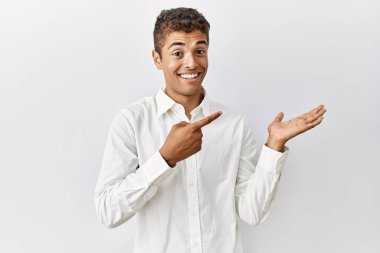 Soyutlanmış arka planda duran yakışıklı İspanyol adam kameraya hayret ediyor ve gülümsüyor.. 