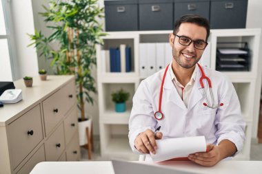 Klinikte çalışan doktor üniforması giyen genç İspanyol adam.