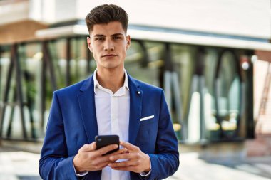 Sokakta akıllı telefon kullanan genç bir adam.