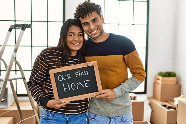 Young Latin Couple Smiling Happy Holding Our First Home Blackboard — Stock Photo, Image