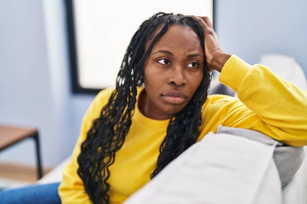 非洲裔美国妇女坐在沙发上 脸上带着严肃的表情 — 图库照片