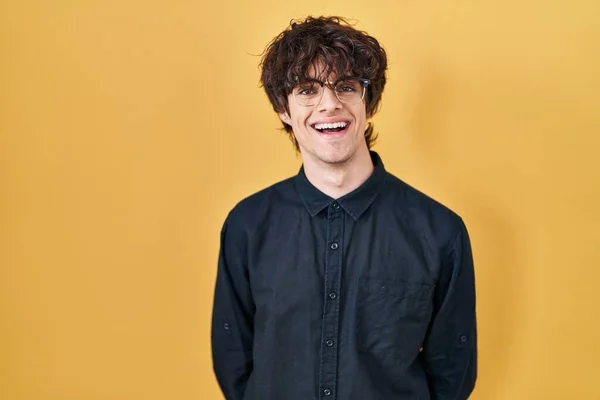 Ung Man Bär Glasögon Över Gul Bakgrund Med Ett Lyckligt — Stockfoto