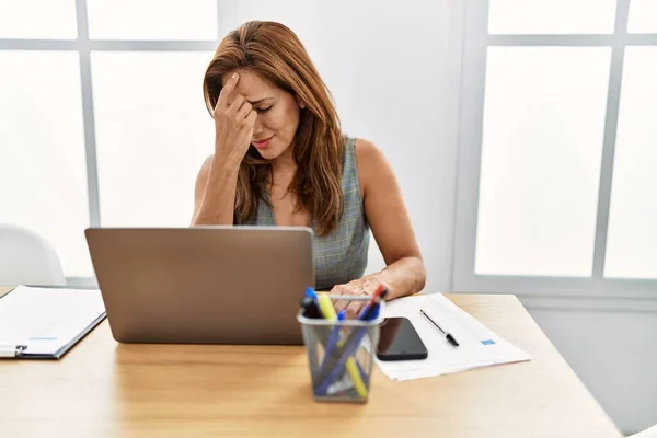 Young latin woman business worker stressed suffering for headache at office