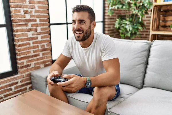 Evde video oyunu oynayarak kendine güvenen İspanyol genç adam.