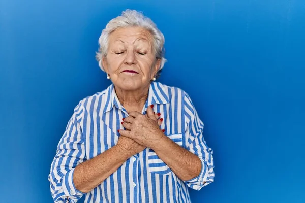 Senior Woman Grey Hair Standing Blue Background Smiling Hands Chest — Stockfoto