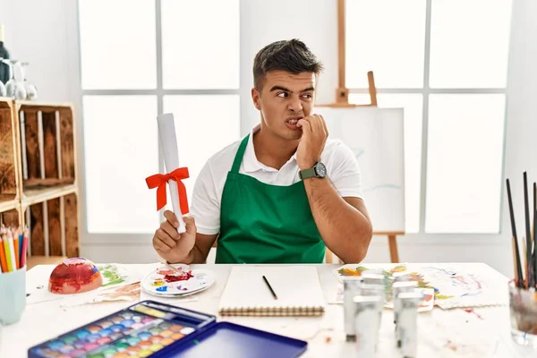 Young Hispanic Man Art Studio Holding Degree Looking Stressed Nervous — Fotografia de Stock