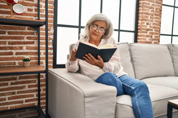 Orta Yaşlı Kadın Kitap Okuyor Evdeki Kanepede Oturuyor — Stok fotoğraf