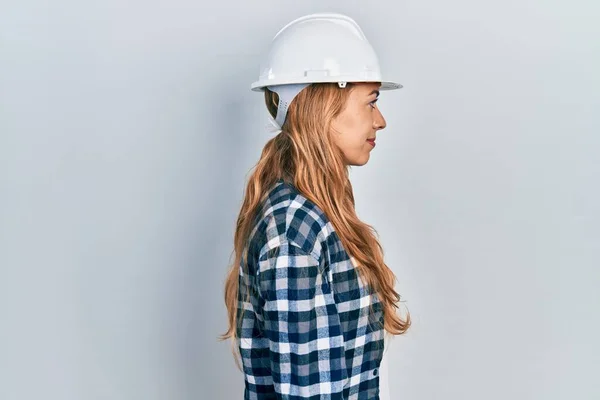 年轻的高加索女人戴着建筑师的硬礼帽 面带微笑 自然地放松姿态 — 图库照片