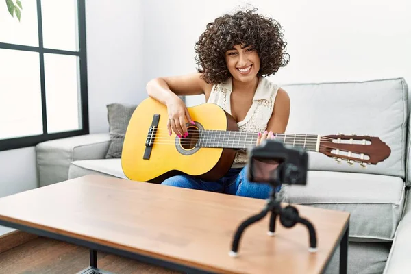 Young middle east woman having online guitar class at home
