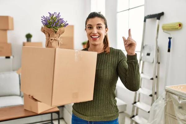 Young Hispanic Woman Holding Cardboard Box Moving Surprised Idea Question — Zdjęcie stockowe