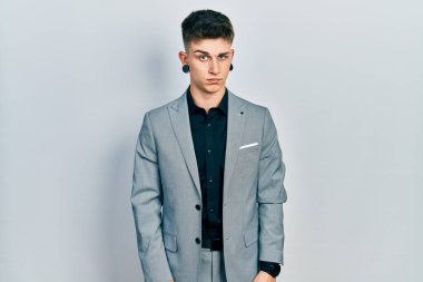 Kulakları genişlemiş, iş ceketi giyen, kuşkucu ve gergin, sorun yüzünden somurtan beyaz bir genç. negatif kişi. 