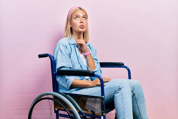Красивая Блондинка Сидящая Инвалидной Коляске Думающая Сомнениях Пальцем Подбородке Глядя — стоковое фото