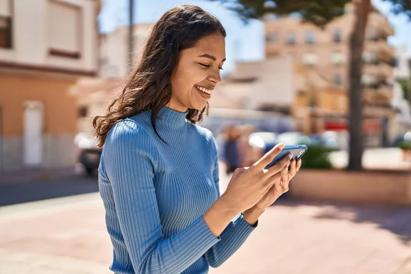 若いアフリカ系アメリカ人女性笑顔自信を持ってビデオを見ますスマートフォン上の通り — ストック写真
