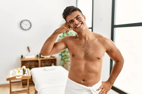 Young Hispanic Man Standing Shirtless Spa Center Smiling Doing Phone — Stockfoto