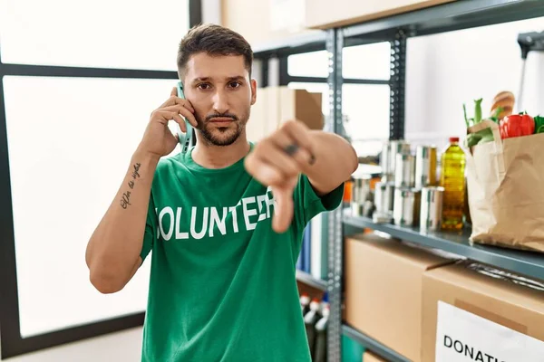 Young Hispanic Man Wearing Volunteer Shirt Speaking Phone Angry Face — Foto de Stock