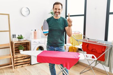 Orta yaşlı, sakallı, evde ütü yapan, bir fikri olan ya da soru soran mutlu yüzlü, bir numaralı adam. 