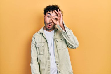 Gündelik kıyafetler giyen genç İspanyol adam şaşırmış yüz ifadesiyle şok olmuş, parmaklarından bakan gözler. İnançsız ifade. 