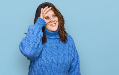 Genç ve cüsseli bir kadın günlük kıyafetler giyiyor. El hareketleriyle gülümsüyor, gözleriyle mutlu yüzlere bakıyor.. 