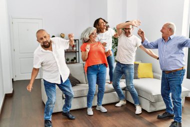 Bir grup orta yaşlı arkadaş evde dans ediyor..