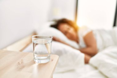 Orta yaşlı İspanyol kadın yatak odasında yatakta uyuyor.