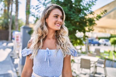 Genç sarışın kız gülümsüyor mutlu bir şekilde Cityl 'de duruyor