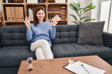 Young brunette woman at consultation office showing and pointing up with fingers number nine while smiling confident and happy. 